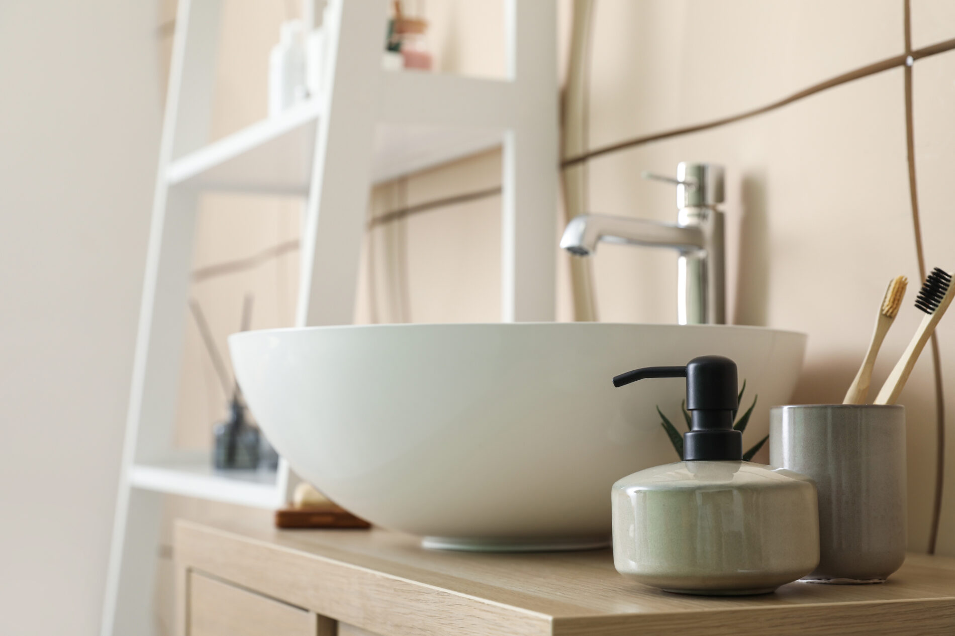 Sink bowl and bath accessories on table in bathroom