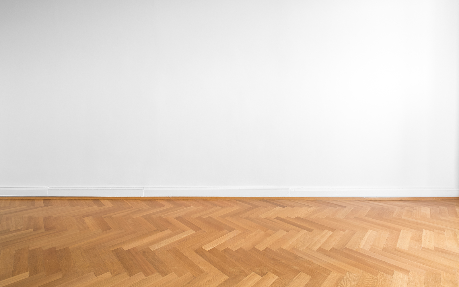 wooden parquet floor and white wall background - empty room , new flat